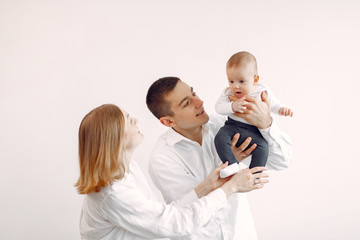 Cute family in a room. Lady in a white shirt. Woman hold child in her hands.