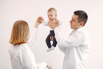 Cute family in a room. Lady in a white shirt. Woman hold child in her hands.