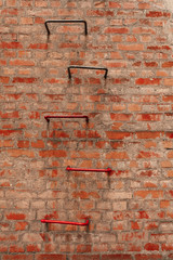 Fragment of old red brick building with fire escape stairs.