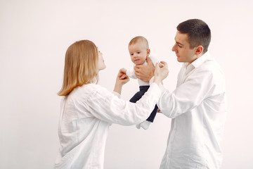 Obraz premium Cute family in a room. Lady in a white shirt. Woman hold child in her hands.