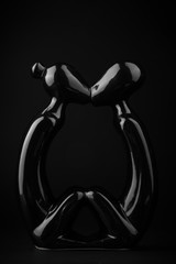 glossy black sculpture on a black background, a piece of furniture