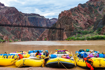 Fototapeta premium River Rafts Tied On Boat Beach With The Black Bridge In The Distance, Colorado River, Grand Canyon National Park, Arizona, USA