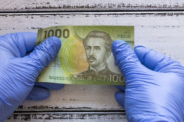 Chile money, Banknote kept in rubber gloves. The concept of economy and financial threats during...