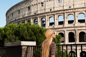Travel woman with hat sitting and looking on the Colosseum, Rome. tourist in Italy