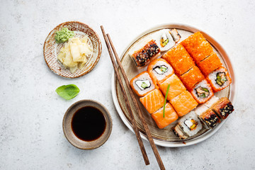 Set of sushi and maki with soy sauce over white background. Top view with copy space