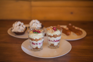 three kinds of desserts on white plates on a wooden table