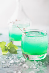 glass of cold drink with fresh mint leaves and ice cubes