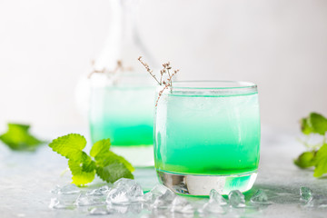 glass of cold drink with fresh mint leaves and ice cubes