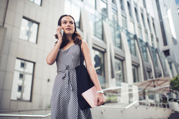 Fototapeta premium Calm adult woman looking away while phoning on street