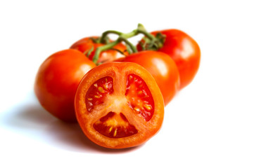 ripe juicy tomatoes isolated on a white background, one tomato cut across in half