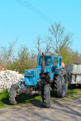 Old tractor in the village on the construction