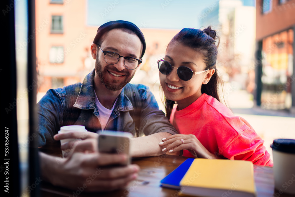 Poster smiling hipster guys watching positive video vlog during networking social website via smartphone te