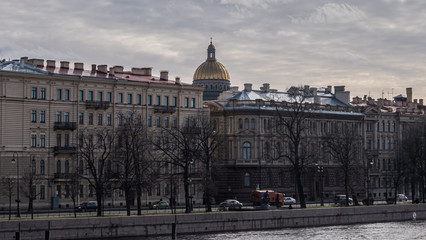 Fototapeta premium Buildings on the banks of the Neva and the gilded dome of St. Isaac's Cathedral.