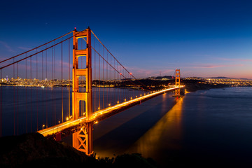 Fototapeta na wymiar Sunset over the Golden Gate Bridge with the skyline of San Francisco, California in the background.