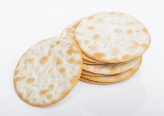 Stack of round organic crispy salty crackers on white.Top view