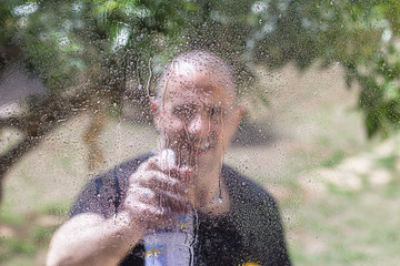 Man cleaning window outside on sunny day - 337863274