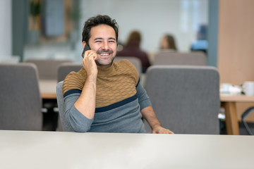 Naklejka premium A handsome man who happily talks to his lover on a smartphone