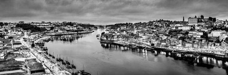 Obraz premium Black and white night cityscape panorama skyline of Porto old town, Luis I Bridge and river Douro banks with reflections.