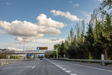 Fototapeta na wymiar M-30 ring road in Madrid, Spain with less traffic than usual due to the state of alarm decreed by the government due to the Covid-19 pandemic and a bright sign that says: Be responsible I stay at home