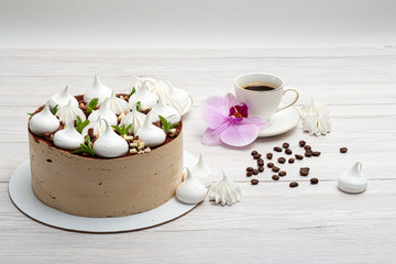 Delicious brown cake with marshmallows and a cup of coffee
