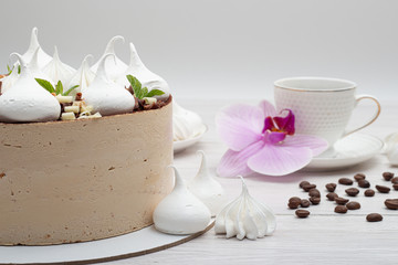 Delicious brown cake with marshmallows and a cup of coffee