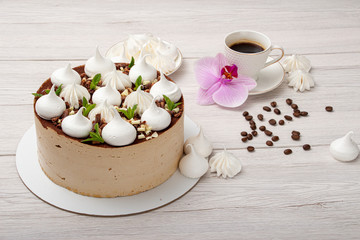 Delicious brown cake with marshmallows and a cup of coffee