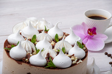 Delicious brown cake with marshmallows and a cup of coffee