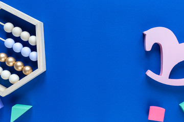 Colorful math wooden abacus and pink horse, blocks  on classic blue background. Interesting, fun math for kids. Education, back to school concept	