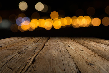 urige Holzplatte vor Hintergrund mit Lichtern und bokeh