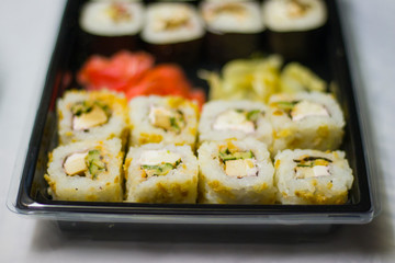 japanese cuisine different rolls with black chopsticks red pickled ginger wasabi sauce and soy sauce on the table