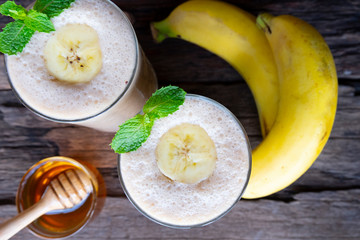 Banana fresh cocktail vanilla smoothies  fruit juice beverage healthy the taste yummy in glass drink episode good morning on wooden background from the top view.