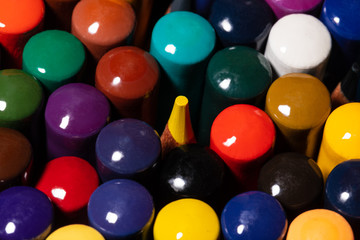 Macro image of a set of Artist's colored pencils in a cup closely grouped with the backs facing up with one yellow pencil tip poking from the center as an OCD trigger nightmare.