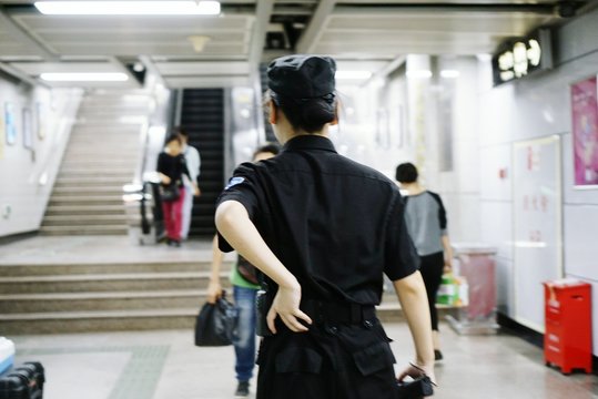 Rear View Of Security Guard At Subway Station