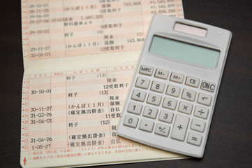 通帳と電卓。家計のやりくりのコンセプト。
