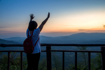 Fototapeta premium Asian women tourist happy freedom during dramatic sunset at Khao Yai,Nation park of Thailand ,Concept of outdoor camping adventure