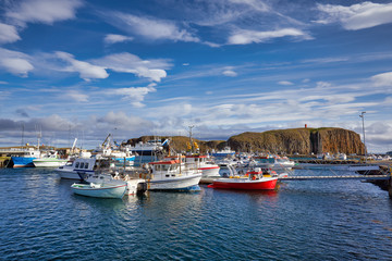 Fototapeta na wymiar Beautiful panoramic view of the Stykkisholmskirkja Harbor with Fishing ships (boats) at Stykkisholmur town in western Iceland. City view from Sugandisey Cliff with lighthouse. Famous colorful houses