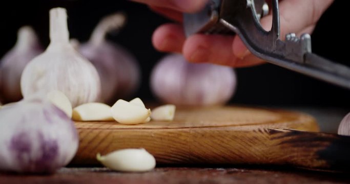 Men hands put a garlic masher.