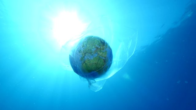 global earth world in plastic ocean pollution underwater sun beams and rays