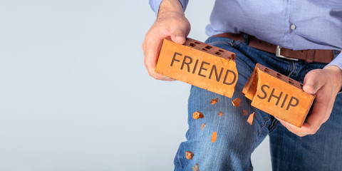 The concept of breaking friendship. Angry man break a brick symbol relation with copy space.