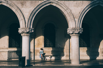 Obraz premium Romantic woman looking at map on bench in sunlight