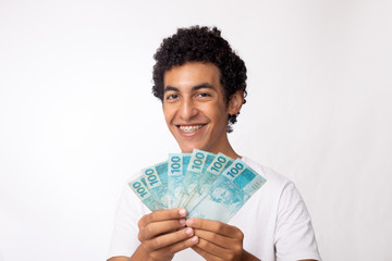 Jovem exibe 600,00 reais em dinheiro brasileiro. Trabalhador brasileiro recebe auxlio emergencial...