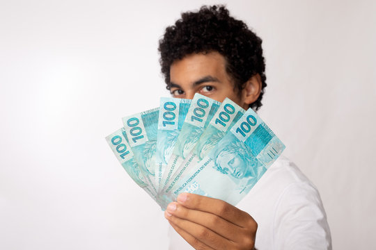 Jovem exibe 600,00 reais em dinheiro brasileiro. Trabalhador brasileiro recebe auxlio emergencial coronavirus, covid-19