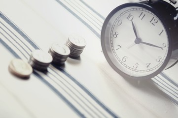 Fototapeta na wymiar Vintage alarm clock and group of growing coins placed on the floor, selective focus and shallow depth of field, investment concept. growing on coin, Business Finance and Save Money.