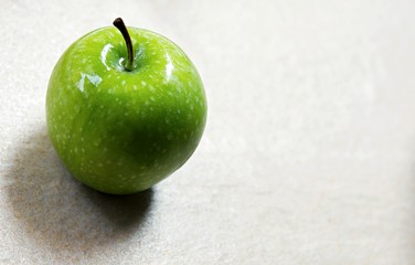 Green Apple with shadow on the floor. 