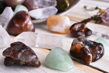 A close up image of fire agate and green aventurine crystals on a wooden table top. 