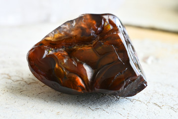 A close up image of a beautiful fire agate crystal on a white background. 
