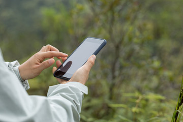 Hands using mobile phone in spring nature