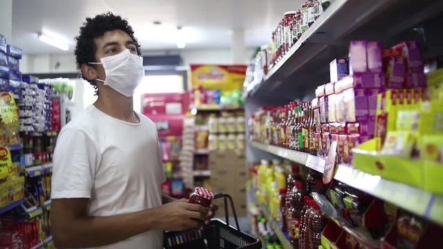 Homem faz compra em supermercado, usando m&aacute;scara de prote&ccedil;&atilde;o contra coronav&iacute;rus, convid-19