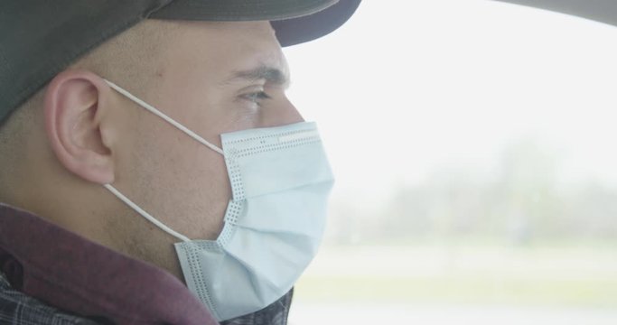 Man with breathing mask driving car close up covid 19 pandemic