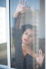 An Indian romantic couple making love standing in front of a window. Intimate couple lifestyle in home quarantine 